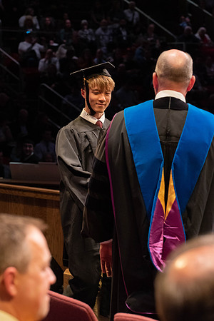 Students graduate and walk to receive their diplomas during convocation in the College of Physical Sciences and Engineering.