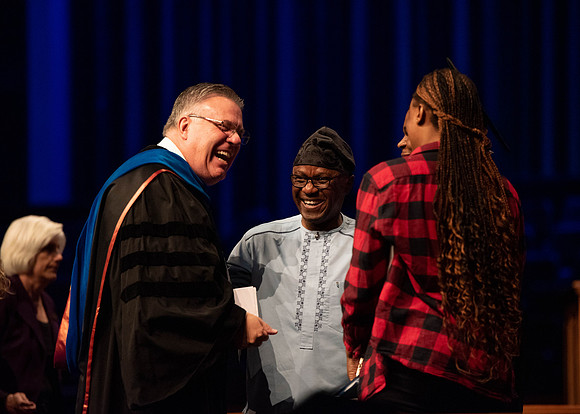 Students graduate and walk to recieve their diplomas during convocation in the College of Business and Communications.
