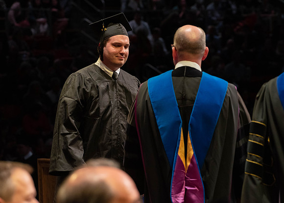 Students graduate and walk to receive their diplomas during convocation in the College of Physical Sciences and Engineering.