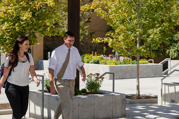 Student and teacher talking as they walk past the library