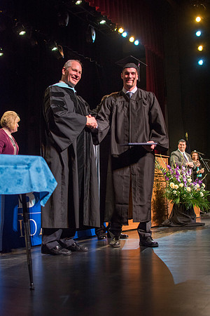 BYU-Idaho graduates accepting their diploma covers at convocation for the College of Interdisciplinary Studies. Photo by Ryan Chase