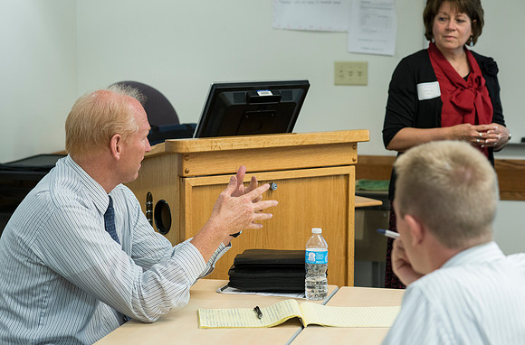 Faculty gather in the Hinckley Building at a Faculty Conference to share and learn from each other at the beginning of the 2013 Fall semester.
