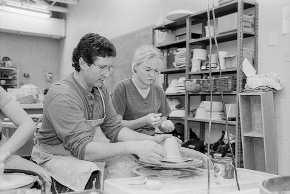 Rich Briggs helps a student as creates her piece of pottery.