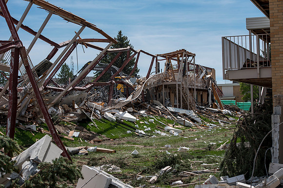 Construction workers work at tearing down the old campus dorms for a new campus project.