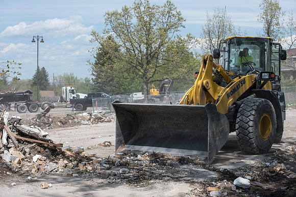 Construction workers work at tearing down the old campus dorms for a new campus project.