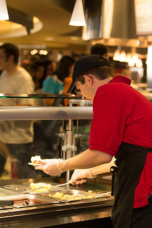 A student employee prepares lunch at Crossroads for incoming students