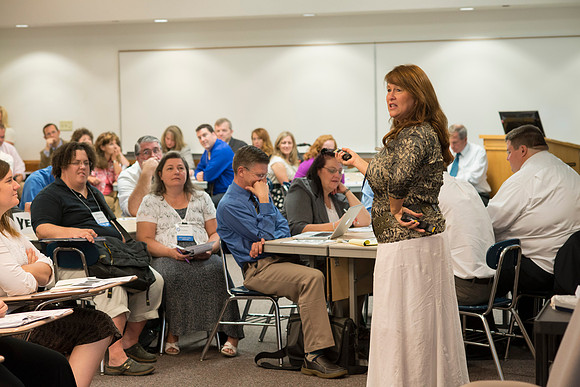 Faculty gather in the Hinckley Building at a Faculty Conference to share and learn from each other at the beginning of the 2013 Fall semester.