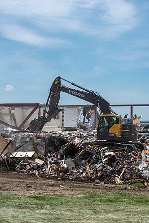 Construction workers work at tearing down the old campus dorms for a new campus project.