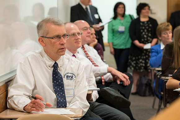 Faculty gather in the Hinckley Building at a Faculty Conference to share and learn from each other at the beginning of the 2013 Fall semester.