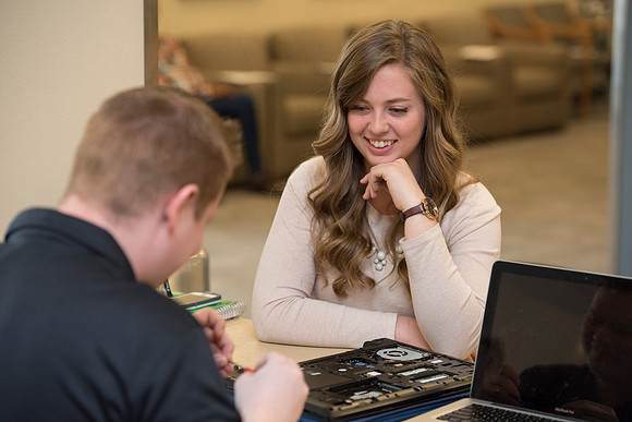 Zach Litchfield from the IT Department helps Sarah Nielsen with her computer.
