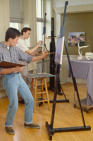 Art student works diligently on a painting.