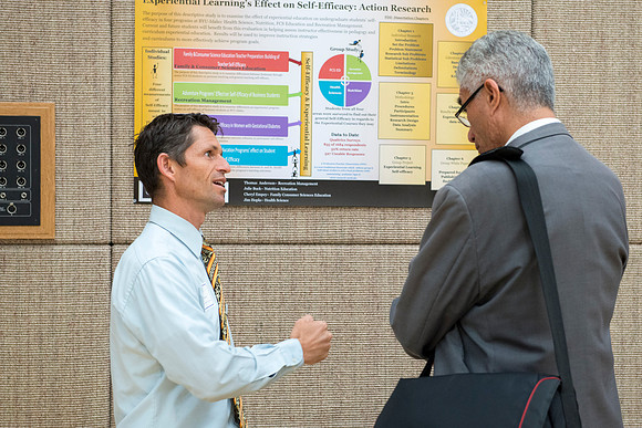 Faculty gather in the Hinckley Building at a Faculty Conference to share and learn from each other at the beginning of the 2013 Fall semester.