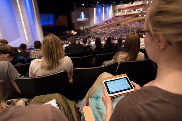 Students at devotional taking notes.