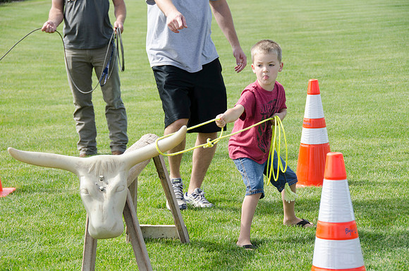 Father helping his son rope a "steer" at BYU-Idaho's first Ag Days
