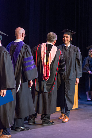 BYU-Idaho graduates accepting their diploma covers at convocation for the College of Perfoming and Visual Arts. Photo by Ryan Chase