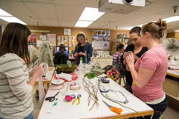 Horticulture students prepare for a semester review fashion show that will show their floral designs as well. Brother Romney leads the students along with other instructors.