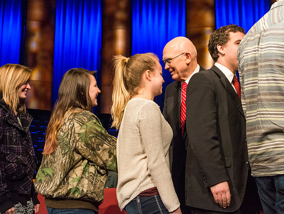 President Kim B. Clark, President of BYU-Idaho and Elder Dallin H. Oaks, Quorum of the Twelve Apostles shake hands with students at Brigham Young University-Idaho. Other students await their turn for
