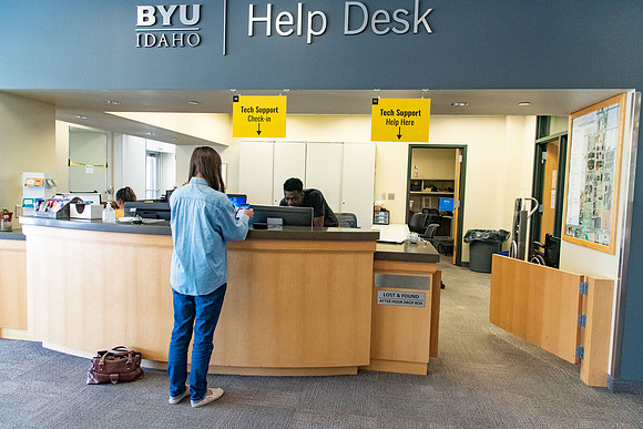 Student employees wearing face masks and working at the Help Desk during the Covid-19 Pandemic.