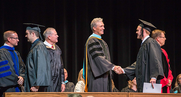 Elder Devin G Durrant and President Clark G Gilbert congratulate graduates.