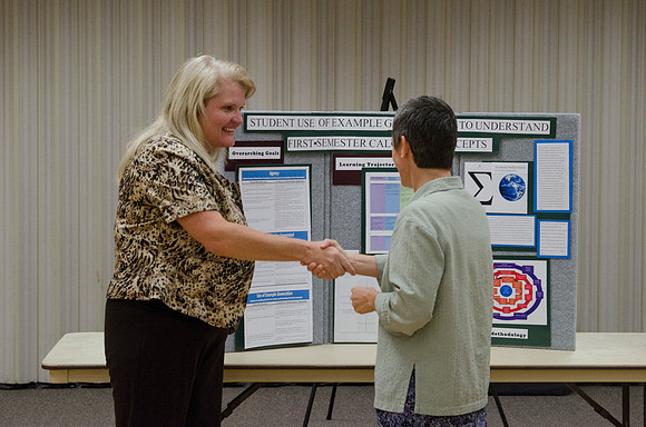 Faculty members talking together at the faculty meeting Fall 2013