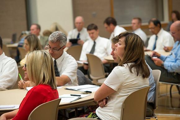 Faculty gather in the Hinckley Building at a Faculty Conference to share and learn from each other at the beginning of the 2013 Fall semester.