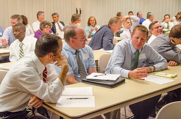 Faculty members discussing classroom topics during faculty meeting Fall 2013