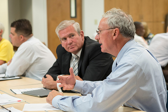 Faculty gather in the Hinckley Building at a Faculty Conference to share and learn from each other at the beginning of the 2013 Fall semester.