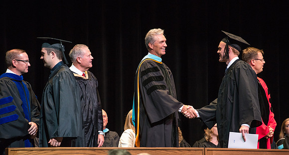 Elder Devin G Durrant and President Clark G Gilbert congratulate graduates.
