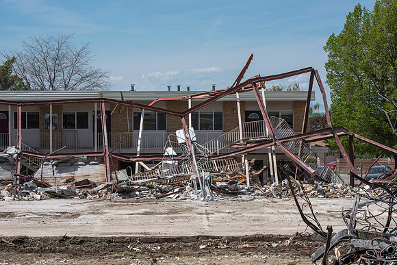 Construction workers work at tearing down the old campus dorms for a new campus project.