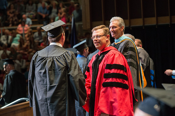 Elder Devin G Durrant and President Clark G Gilbert congratulate graduates.