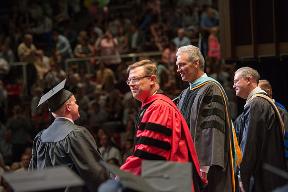 Elder Devin G Durrant and President Clark G Gilbert congratulate graduates.