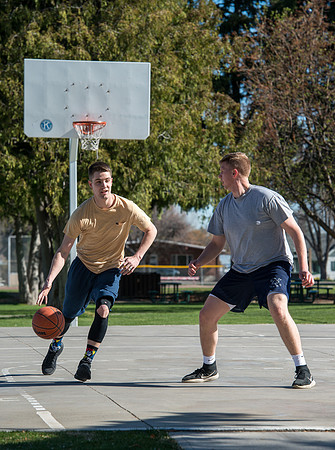 Jacob Kaiser (in yellow) playing basketball, one on one with Jacob Madsen at Smith Park in Rexburg, Idaho.