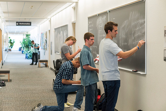 Math students working together on an assignment in the hall of the Ricks Building.