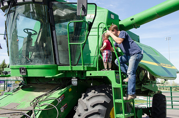 Dad helping his son onto the tractor at BYU-Idaho's first Ag Days