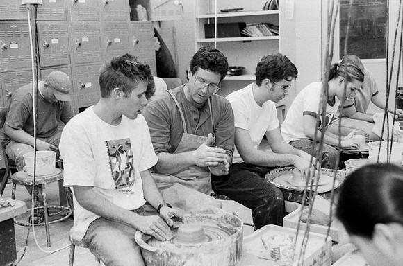 Rich Briggs helps a student as creates his piece of pottery.