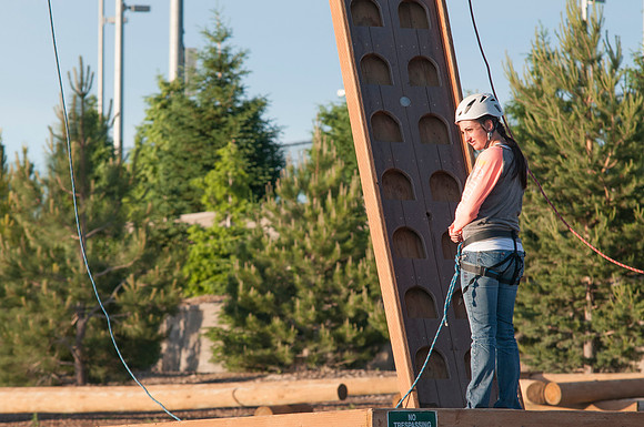 Student preparing and starting to climb ropes course, Spring 2013
