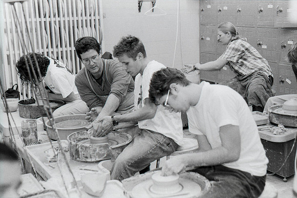 Rich Briggs helps a student as creates his piece of pottery.