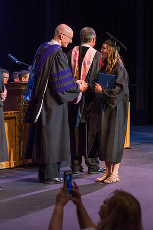 BYU-Idaho graduates accepting their diploma covers at convocation for the College of Perfoming and Visual Arts. Photo by Ryan Chase