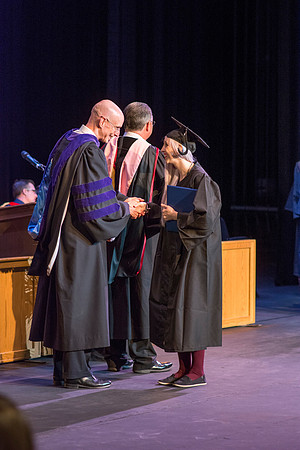 BYU-Idaho graduates accepting their diploma covers at convocation for the College of Perfoming and Visual Arts. Photo by Ryan Chase