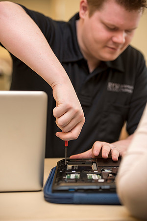 Zach Litchfield from the IT Department helps Sarah Nielsen with her computer.
