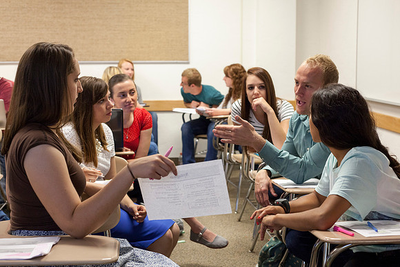 Small groups in Brother Klingler's Communicable and Non-Communicable Disease class, talk about a case study in their group.