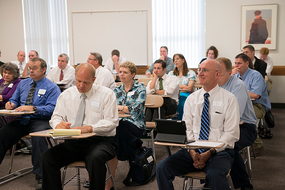 Faculty gather in the Hinckley Building at a Faculty Conference to share and learn from each other at the beginning of the 2013 Fall semester.