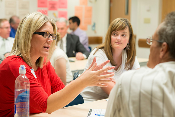 Faculty gather in the Hinckley Building at a Faculty Conference to share and learn from each other at the beginning of the 2013 Fall semester.