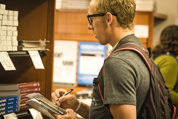 A man picks up textbooks on the first day of classes at the University Bookstore