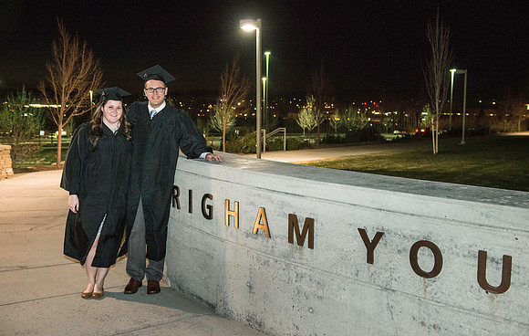 Graduates pose in front of the BYU-Idaho sign on the south side of campus.