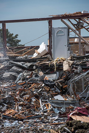 Construction workers work at tearing down the old campus dorms for a new campus project.