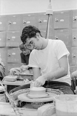 Art student works diligently on creating a piece of pottery.