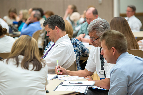 Faculty gather in the Hinckley Building at a Faculty Conference to share and learn from each other at the beginning of the 2013 Fall semester.