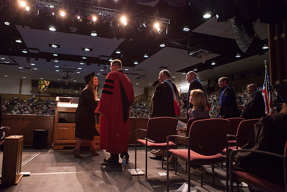 President Gilbert, Elder Ronald A. Rasband, Kirk D. Gifford, Rick L. Hirschi, Keith F. Patterson, and Steven E. Rigby award diplomas at the College of Business and Communication convocation in the Har