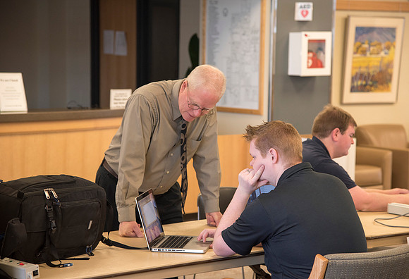 Zach Litchfield from the IT Department helps University Photographer, Mike Lewis, with his computer.